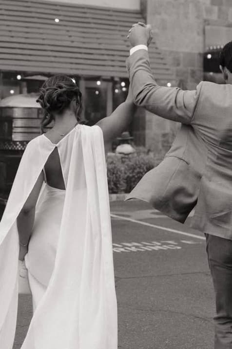 Couple walking hand-in-hand at an evening event, her hair styled in a soft low updo.