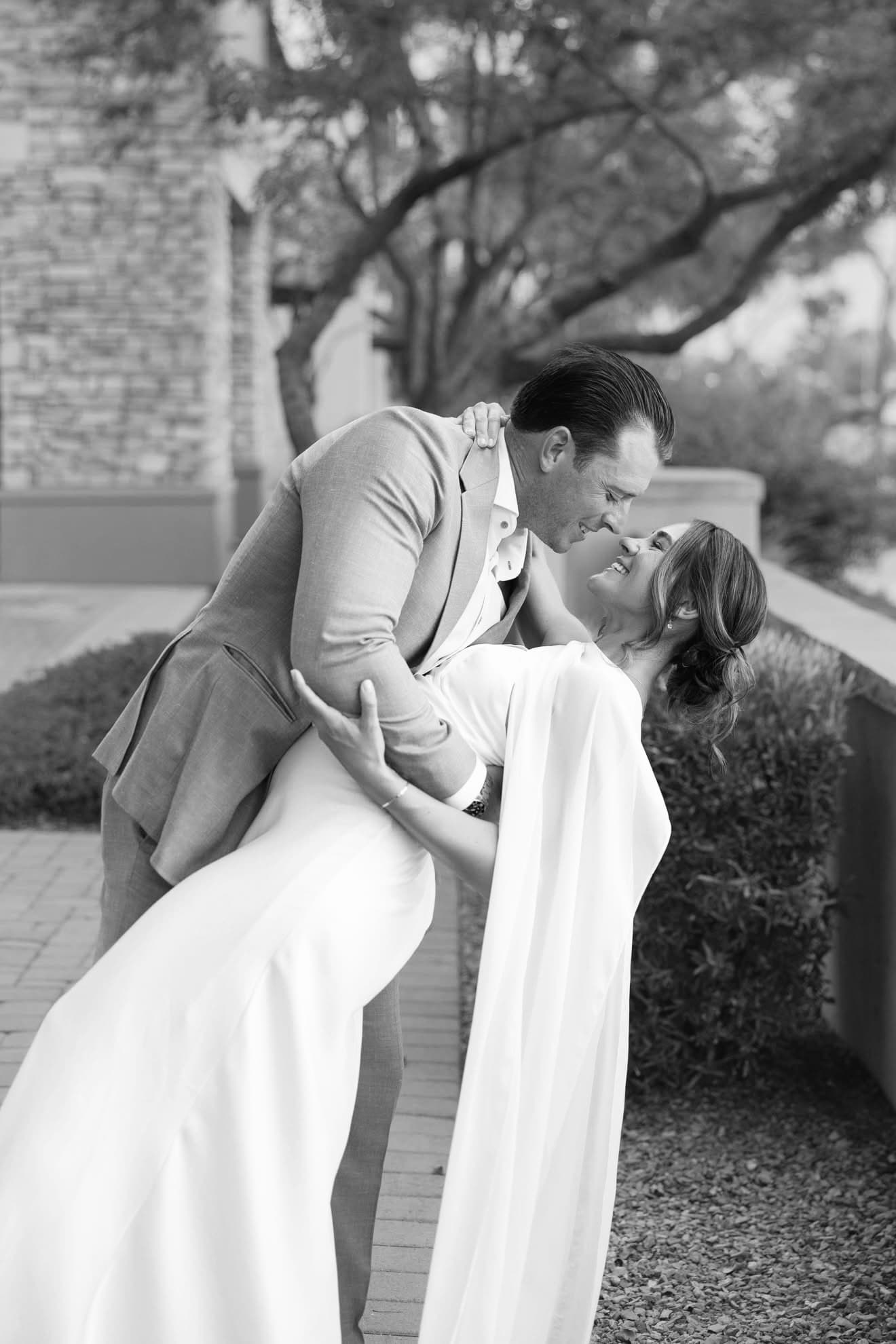 Couple sharing an embrace at an evening event, her hair styled in a romantic updo.